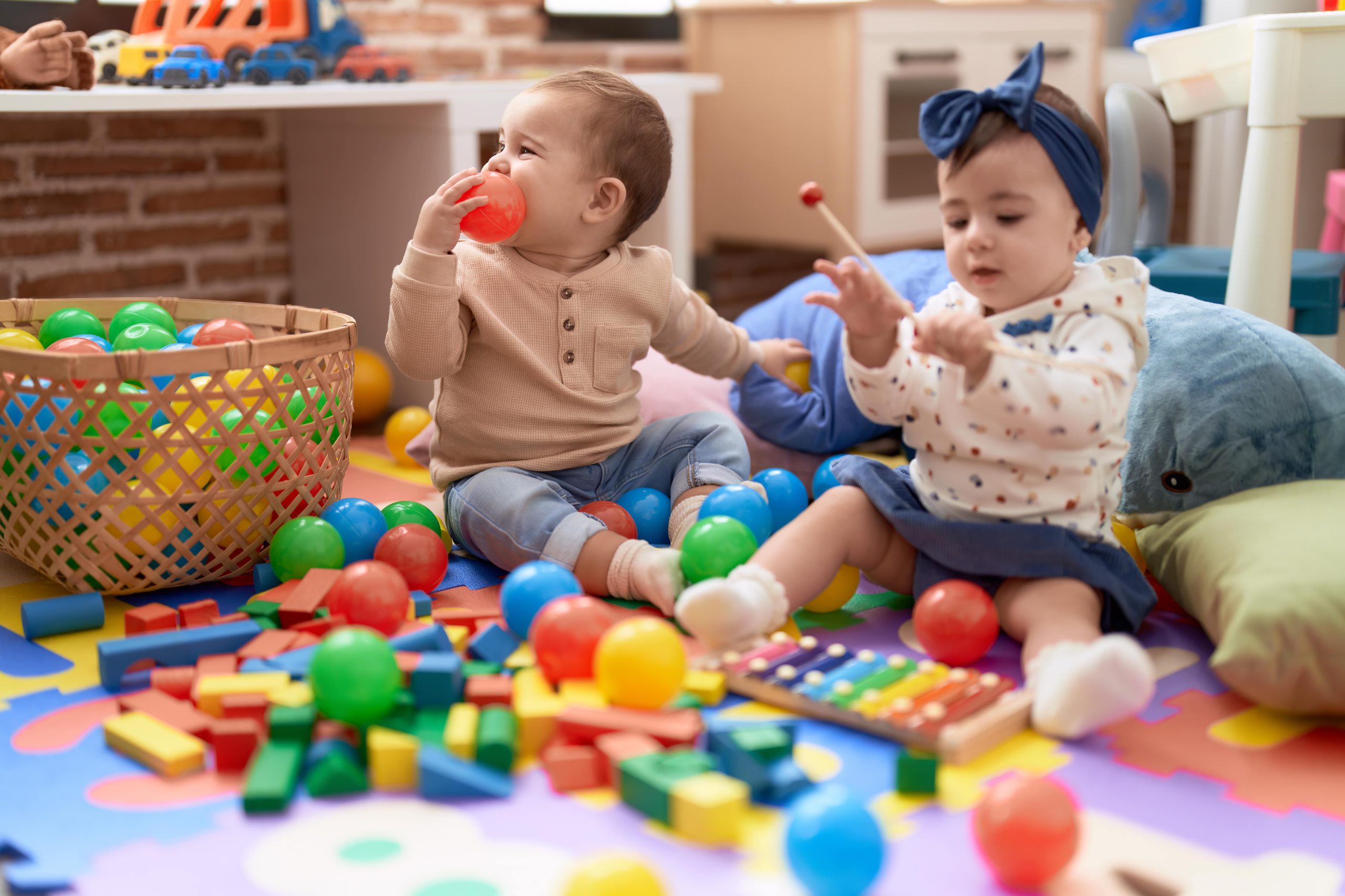 two-toddlers-playing-with-balls-xylophone-sitting-floor-kindergarten-min